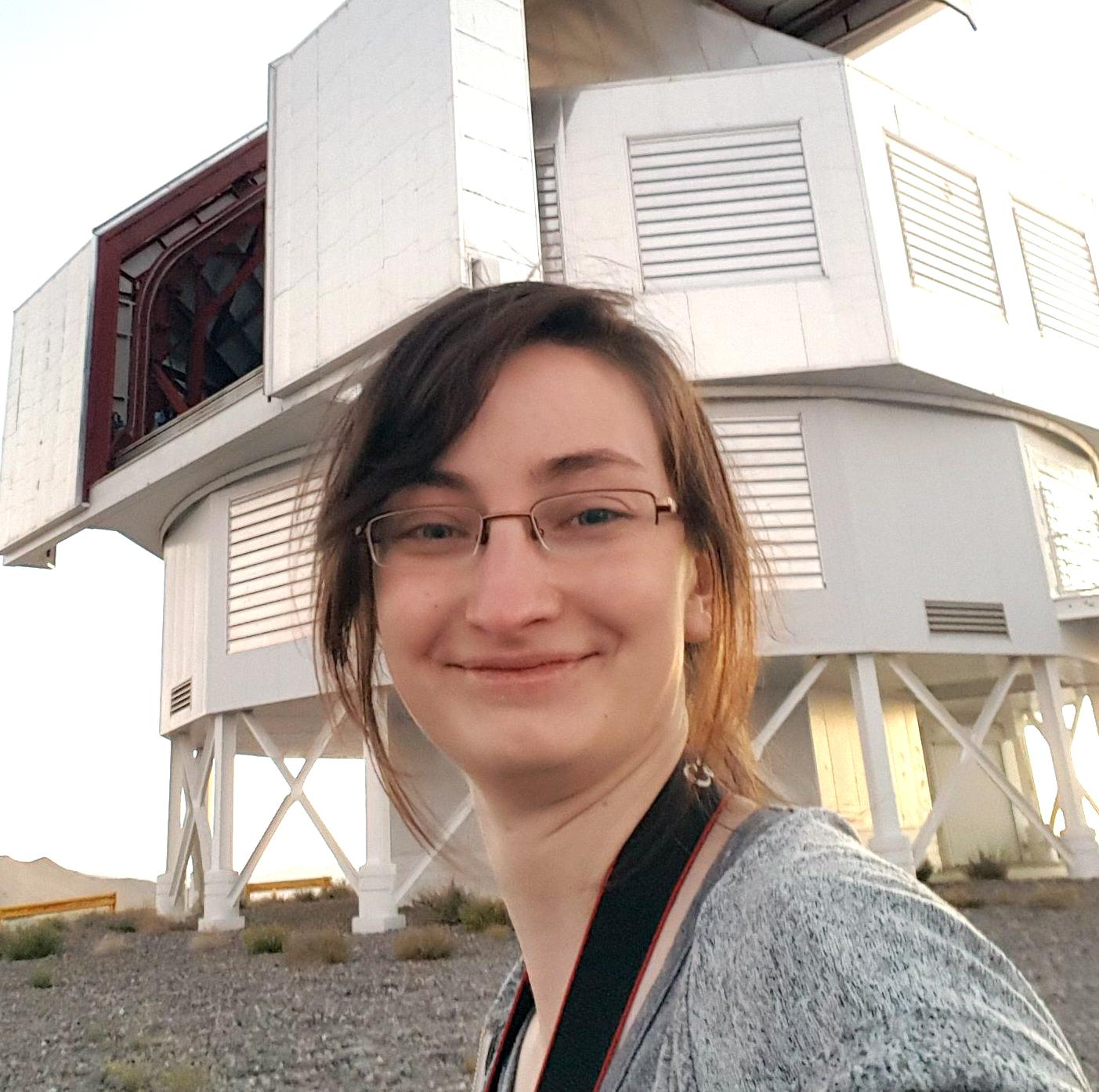 Anna O'Grady poses in front of the Magellan Telescopes.