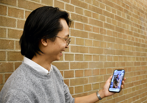 Bryan Hong holding a phone.