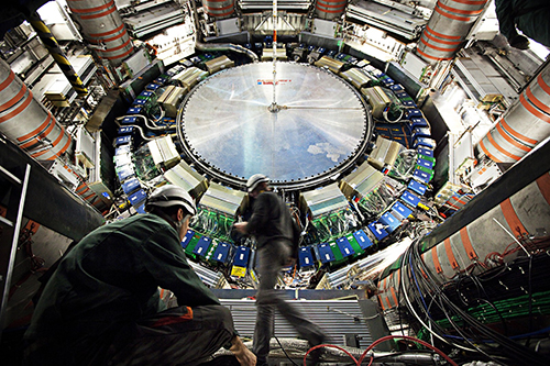 Two men in hardhats inside the ATLAS detector on the Large Hadron Collider