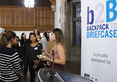 People mingling in front of a b2B banner.