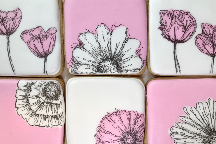 White and pink sugar cookies with beautiful paining flowers in black and white.