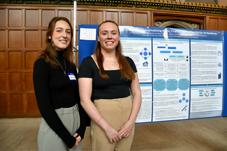 Katerina Carrozzi, Victoria College and Caroline Carruthers, Trinity College standing beside posters of their research.