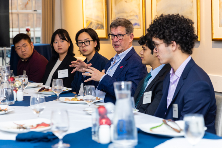 Geoff Chutter speaking with five undergraduate students.