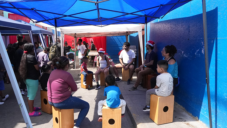 People sitting in a circle under a tent