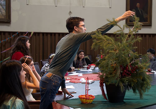 A student holds a branch on a small tree