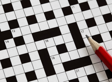 A crossword puzzle with a red pencil.