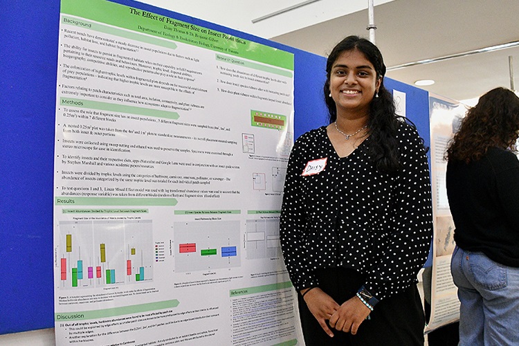 Daisy Thomas standing beside her research slide