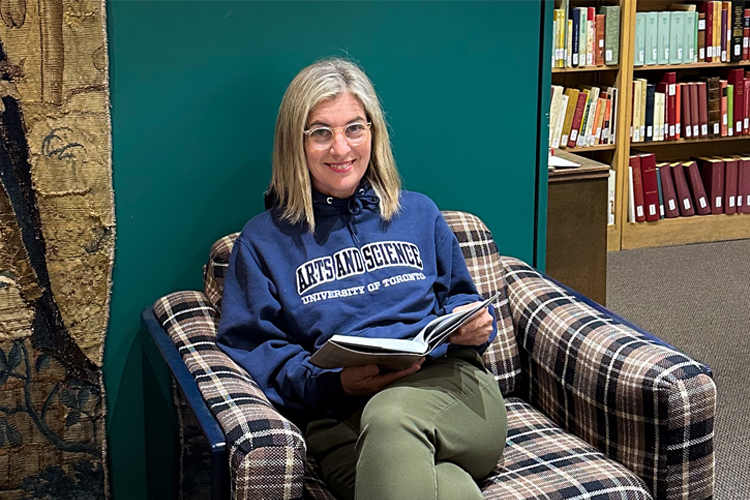 Dean Melanie Woodin sitting with a book.