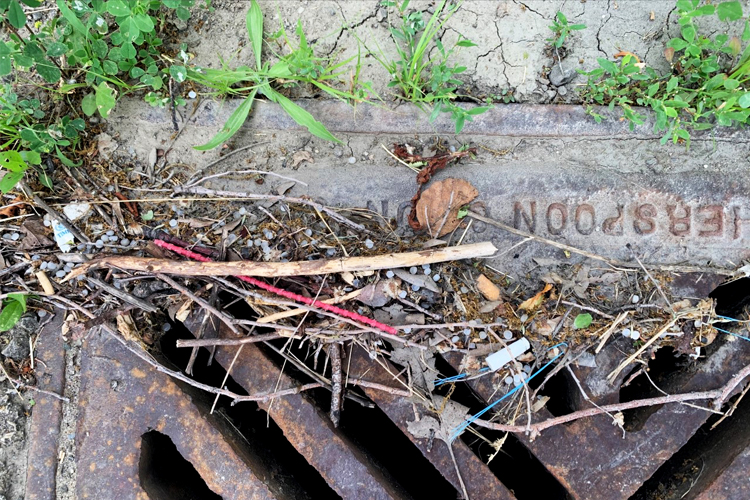 Garbage on top of a sewer grate.