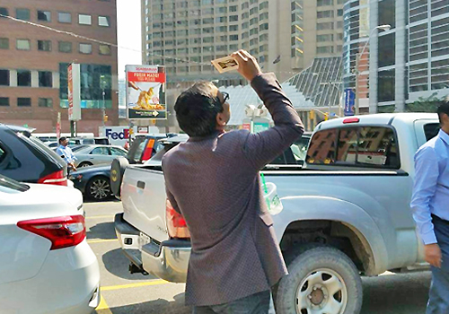 A person standing on a street looking up at the sky.