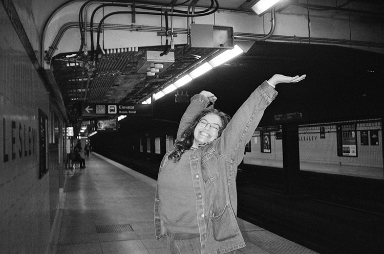 Student Eleanor Lindsay leaping for joy on a subway platform
