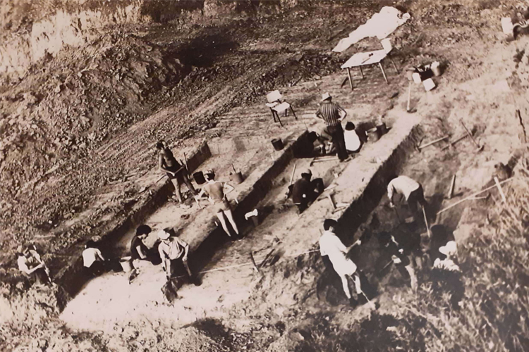 Several people digging a trench in the desert