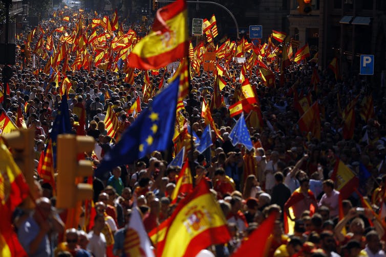 Demonstrators carrying flags marching in protest