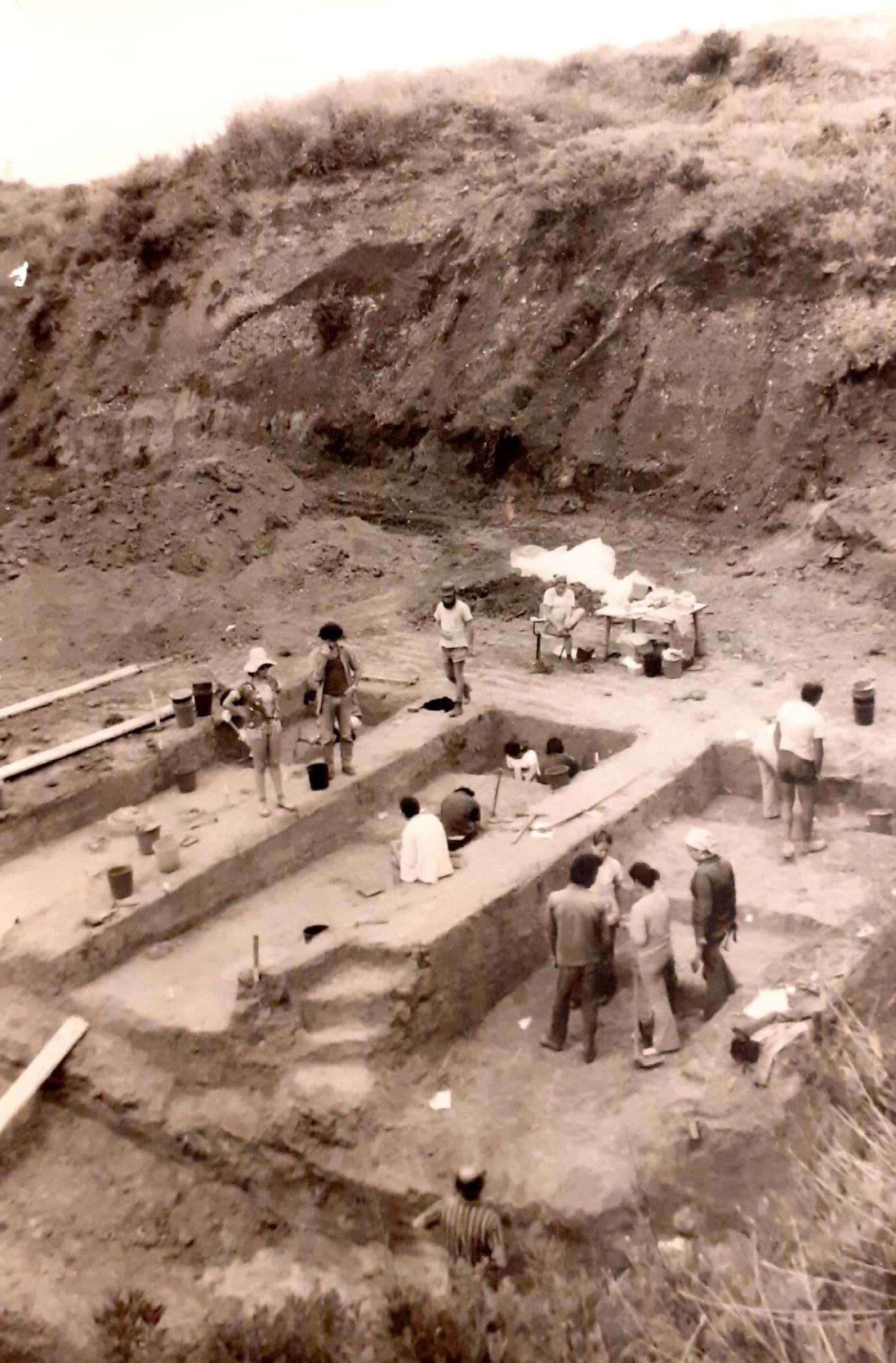 an archival photo of many people on an archeological dig