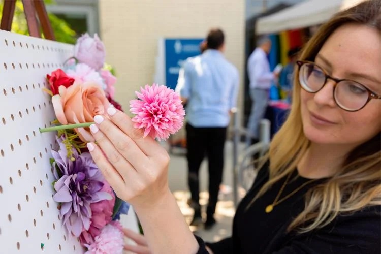 A person putting a flower into a wall display