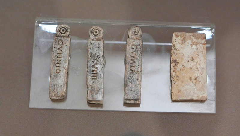 Four stones in a glass case with ancient writing on them
