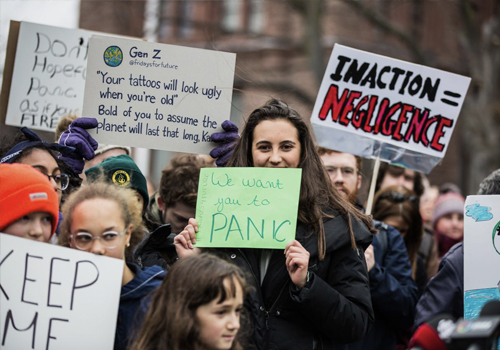 A group of people holding signs such as "Inaction = negligence" and We want you to panic."