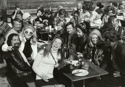 Professor Emeritus Linda Munk sitting with a large group of friends laughing.