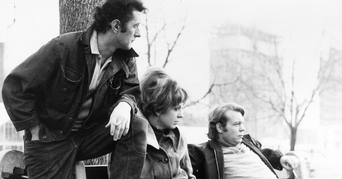 Paul Bradley, Jayne Eastwood, and Doug McGrath sitting on bench in a scene from the film 'Goin' Down The Road'