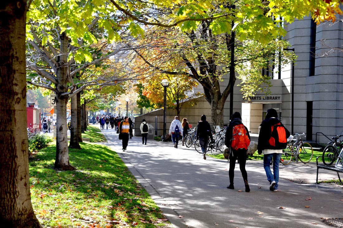 A group of students walking on a sidewalk.