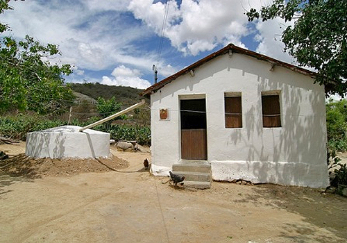 A white stucco house with a cistern 