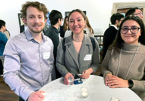 Brandon Fawkes, Laura Gravelsins and alumni mentor Kimia Karbasi standing in a crowded room.