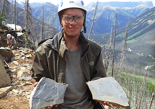 Joseph Moysiuk holding two fossil slabs