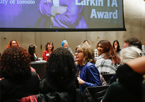 June Larkin sitting at a table with many people.