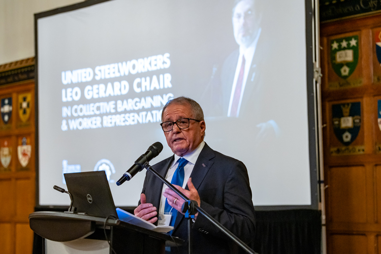 Ken Neumann presenting information at a podium.