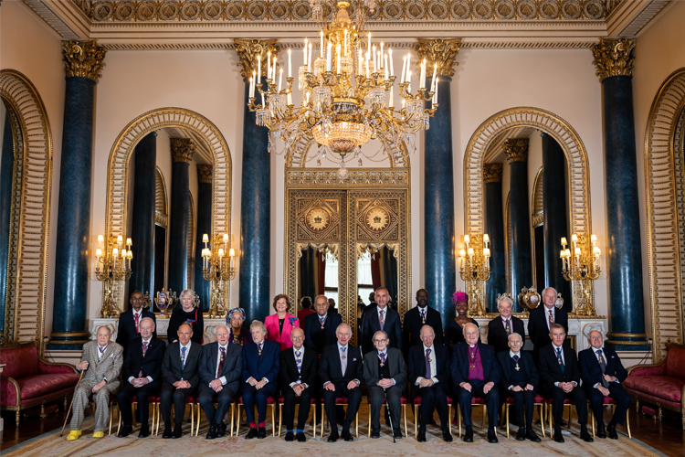 A large group of people posing in Buckingham Palace - KING CHARLES is front row centre
