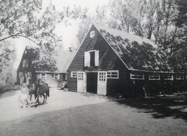 A black and white photo of the original Jokers Hill buildings, including a person and two horses