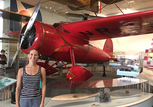 Alumna Lindsay Zier-Vogel beside a red plane.