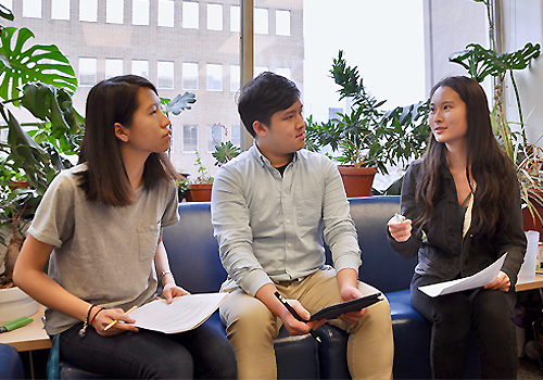 Three students sit to discuss a project.