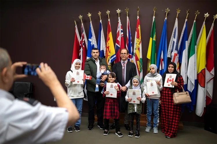 Mark Lautens posing with a group at a citizenship ceremony