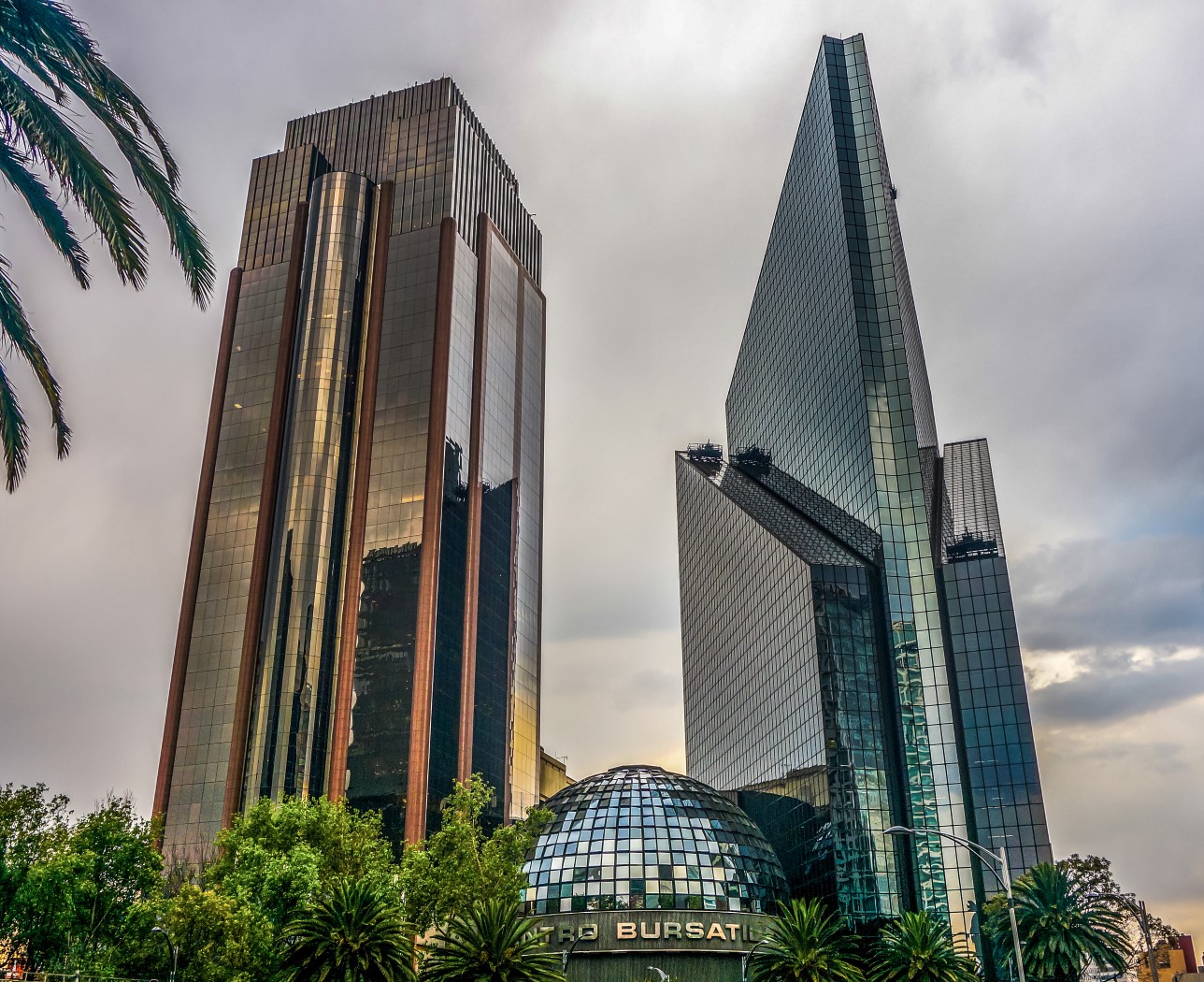 Two glass skyscrapers with a dome-shaped building between them