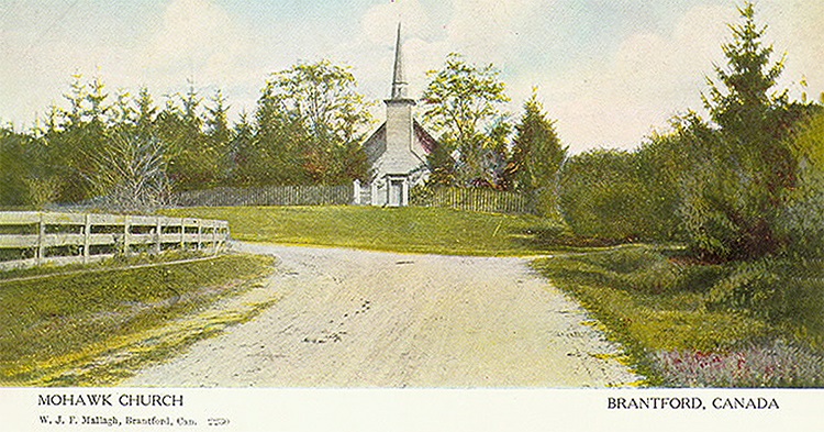 A vintage postcard of a wooden church on a dirt road