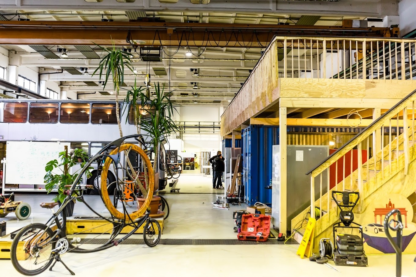 The inside a large building with a bus, bikes and other objects for urban mobility.