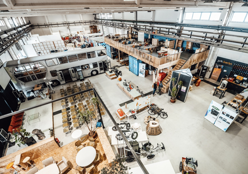 The inside a large building with a bus, bikes and other objects for urban mobility.