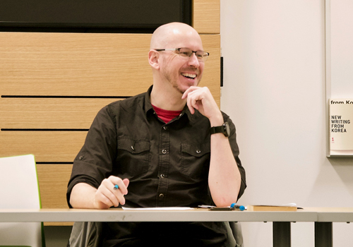 Nathan Sanders sitting at a table laughing