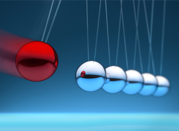 A Newton's Cradle with a red ball.