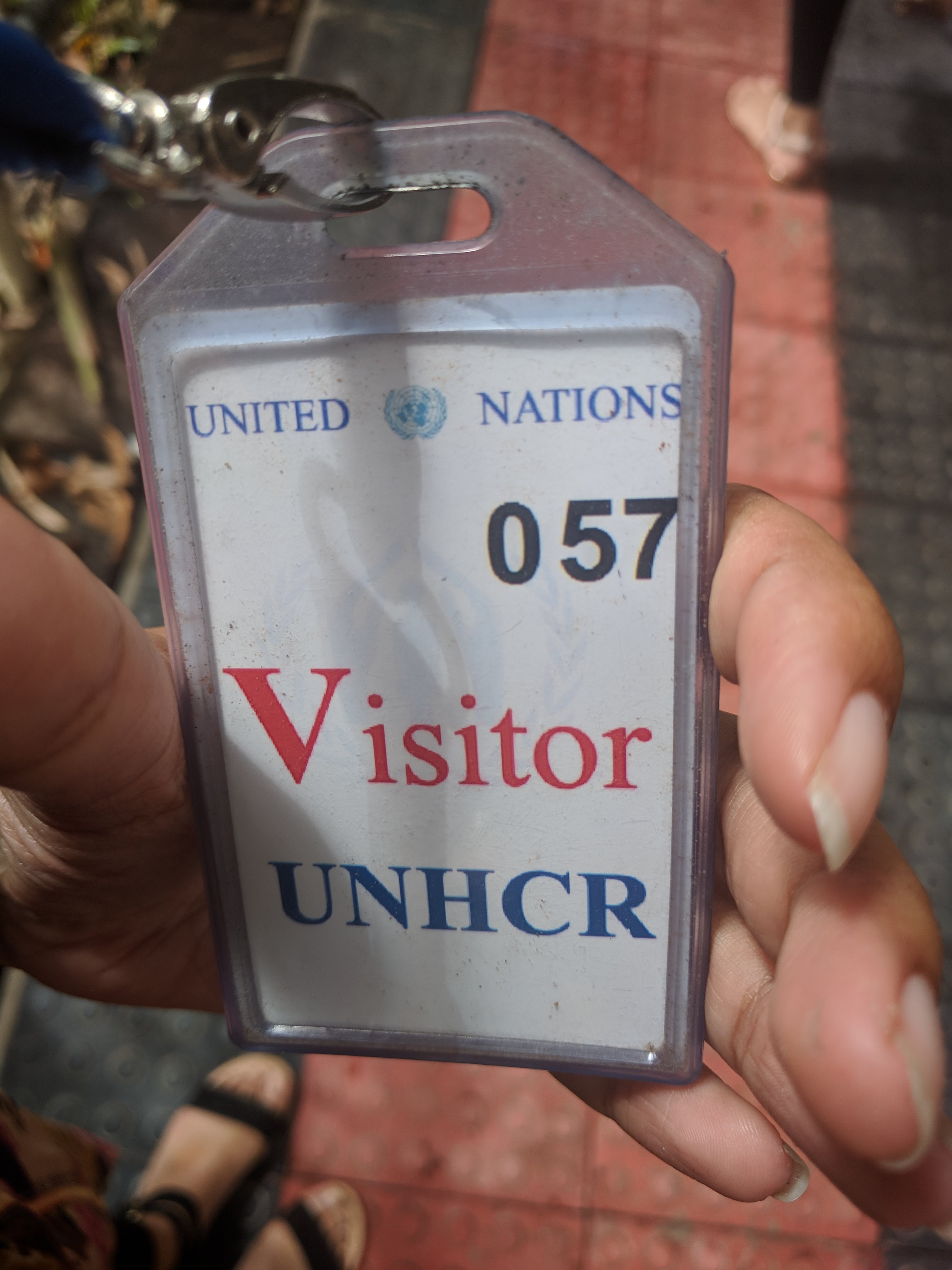 hand holding UNHRC visitor pass