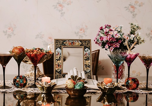 A table with glasses and a mirror and colourful glass orbs