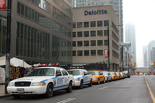 New York City police and taxi cars parked on  downtown Toronto street
