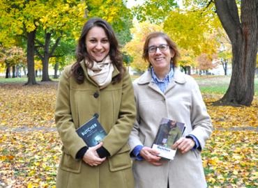 Dragana Obradović and Christina Kramer in winter coats in a field full of fall leaves