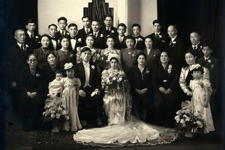 A black of white photo of a group of people gathered for a wedding.