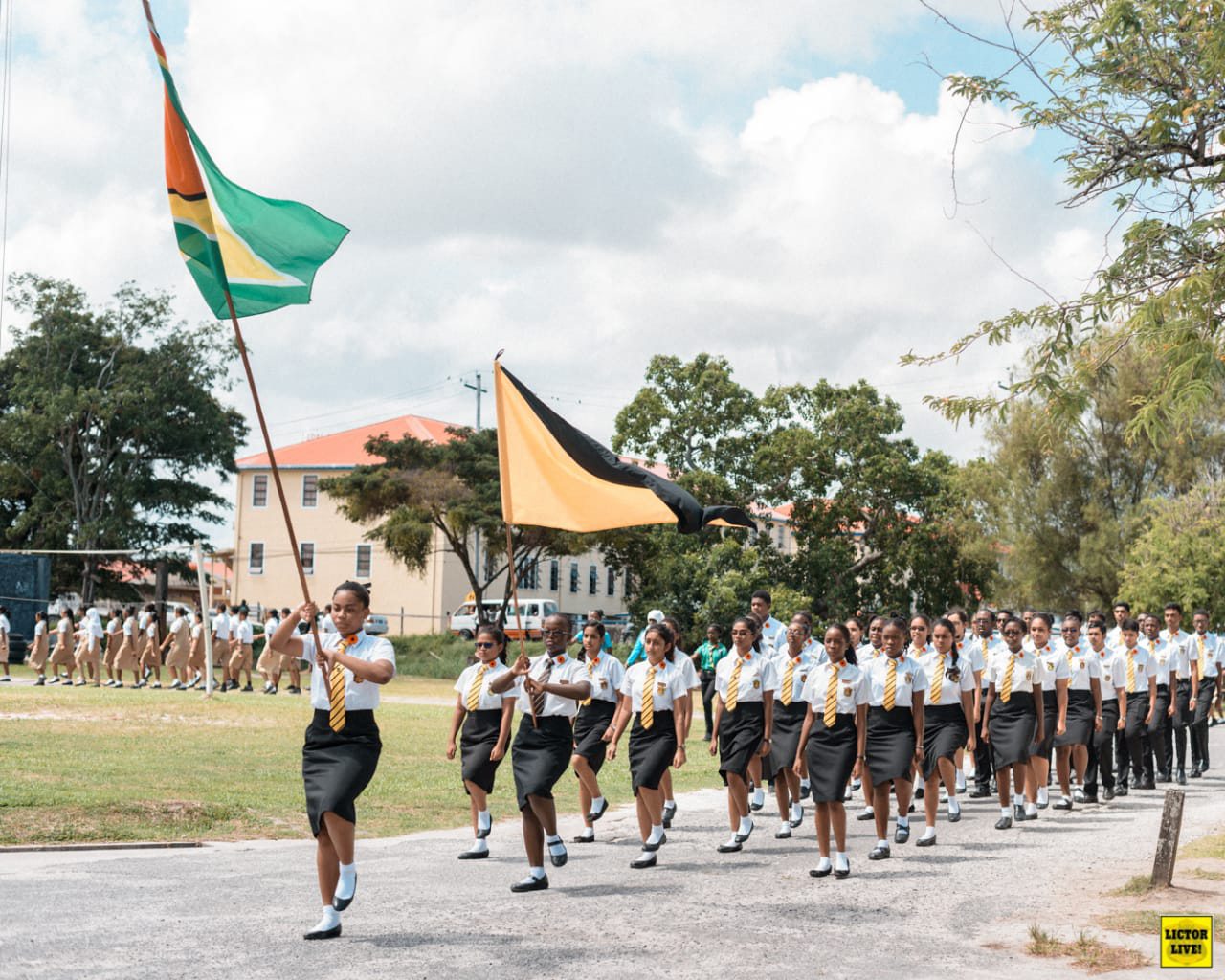 Alyssa Nurse (holding first flag) and her high school class in Guyana for a Remembrance Day Ceremony.