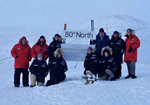 A group of people at the 80˚N sign.