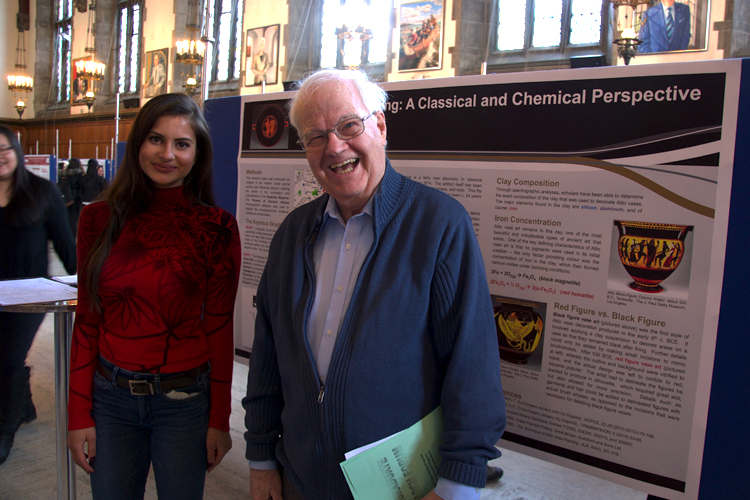 A student and professor standing in front of a poster board
