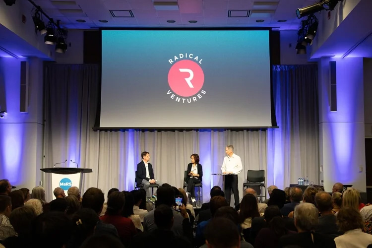 AI luminaries Fei-Fei Li and Geoffrey Hinton on a stage together talking to a man asking questionss