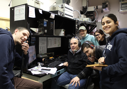 A group of people inside an office talking on a radio.